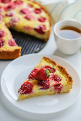 Slice of strawberry pie with a cup of tea on the table