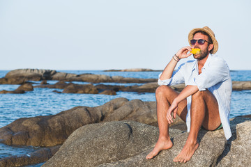 Young man eating corn on the beach © marjan4782