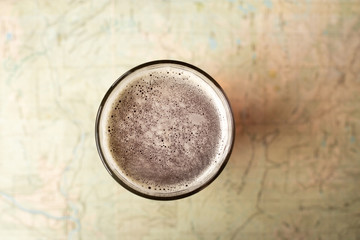 Top down view on a pint glass of beer, on a topographical map