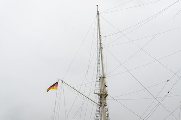 German flag waving on a tall ship sail rigging mast