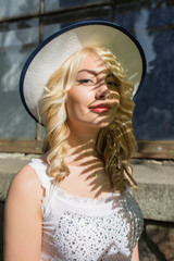 Fototapeta premium Fabulous young model with lush blonde hair posing with shadow of fern