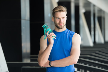 Thirst and health. Sportsman hold water bottle on stadium. Fit man with plastic flask outdoor. Stay hydrated and healthy. Water is part of healthy training. Sport and fitness