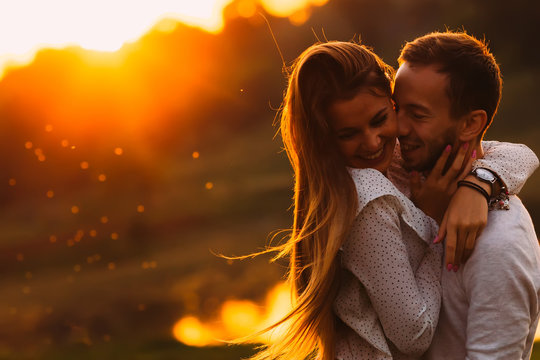 passionate hug of a couple in love on the shore of an evening la