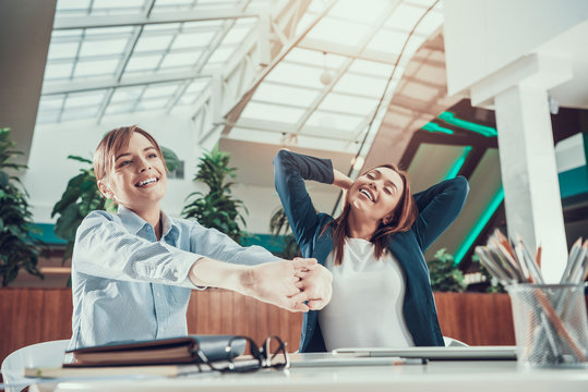 Two women exercising in office.