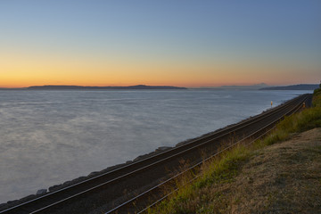 Fototapeta premium Sunset over railroad and ocean