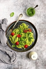 Spaghetti pasta with pesto sauce and cherry tomatoes.Top view.