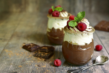 Chocolate mousse with whipped cream and fresh raspberry.