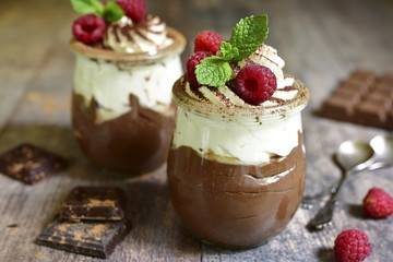 Chocolate mousse with whipped cream and fresh raspberry.