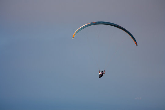 para-glider flies over the ocean against the sky