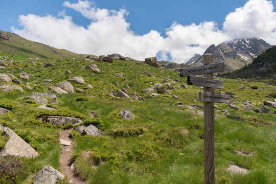 Wooden fingerpost in the French Pyrenees pointing along a footpath to the Refuge du Rulhe, Laparin and the Etangs de Fontargente, which are found on and near the GR10 hiking route.