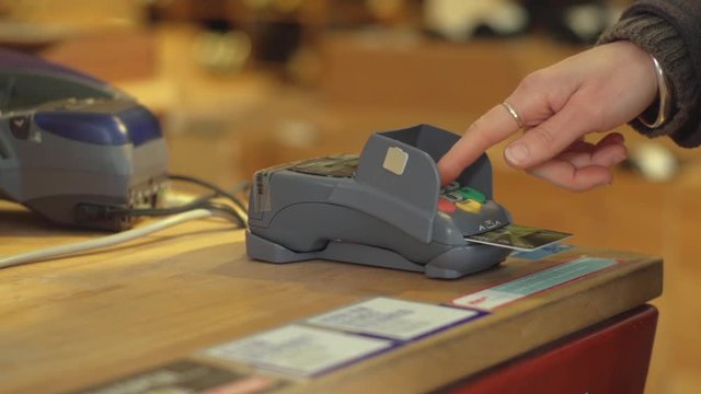 Close up, person uses card reader in store