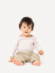 Baby boy sitting on the floor, calm and relaxed