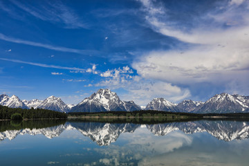 The Grand Tetons of Wyoming are reflected perfectly in the still waters of Jackson Lake