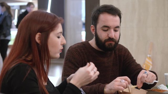 Portrait of young couple eating at fast food and chatting