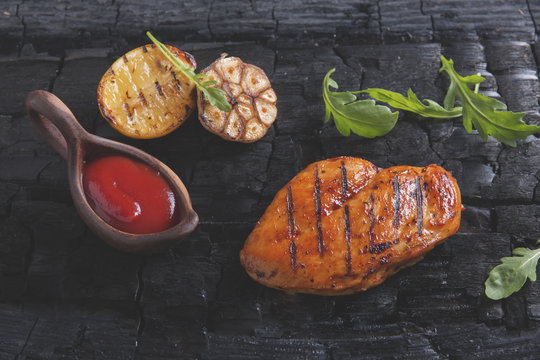 Grilled chicken fillet with sauce on charcoal