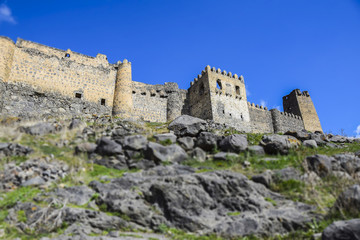 tilt shift landscape castle in the mountains stones mountains grass blue sky