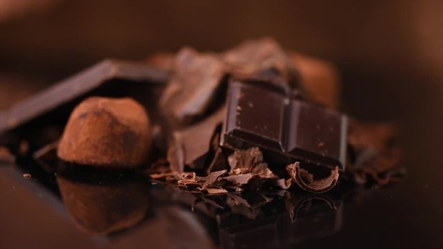 Chocolate. Assorted chocolate sweets and candies rotated over dark background. Confectionery concept. Rotation. 4K UHD video 3840X2160