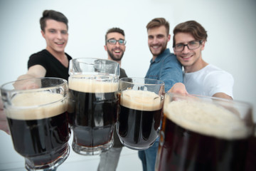 close up.mugs of beer in the hands of a group of men