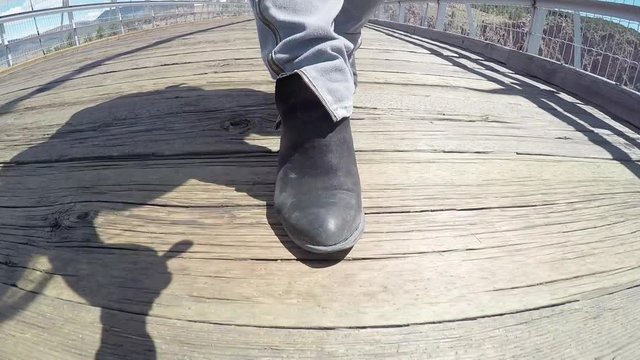 Person walks on wooden bridge at Echo Canyon, low angle