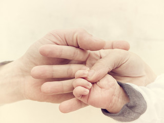 Family Hands together. Hands of father, mother, keep little feet baby. 