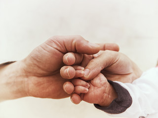 Family Hands together. Hands of father, mother, keep little feet baby. 