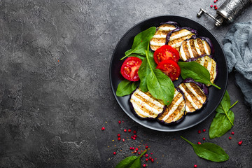 Grilled eggplant with fresh tomatoes and spinach leaves