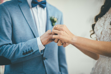 Obraz na płótnie Canvas Bridegroom put an engagement ring on bride.
