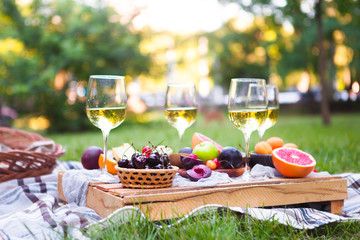 Picnic background with white wine and summer fruits on green grass, summertime party - 210752791