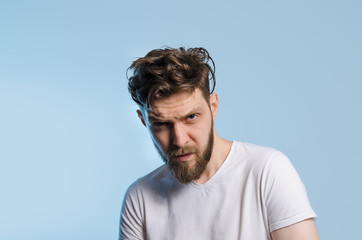 Bearded hipster man in white shirt on baby blue background 