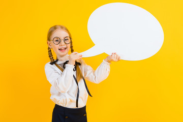 Girl with red pigtails on a yellow background. A charming girl in round transparent glasses is holding a white text box.