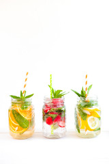 Homemade iced lemonade with mint, summer fruits and berries in a mason jar. Copy space background