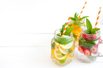 Homemade iced lemonade with mint, summer fruits and berries in a mason jar. Copy space background