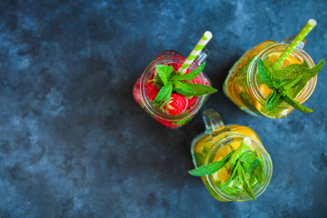 Fototapeta na wymiar Fresh lemonade with mint, summer fruits and berries in mason jar. Copy space background, top view