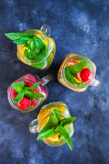 Homemade iced lemonade with mint, summer fruits and berries in a mason jar. Copy space background, top view