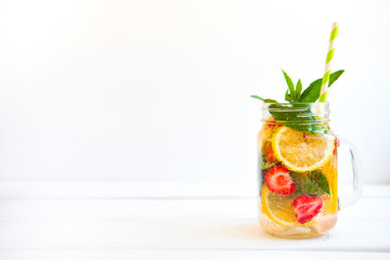 Homemade iced Fresh lemonade with mint, summer fruits and berries in a mason jar. Copy space background.