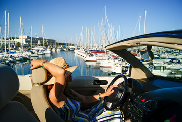 Pretty girl driving her convertible car in Puerto Sherry harbour, Spain © JosManuel
