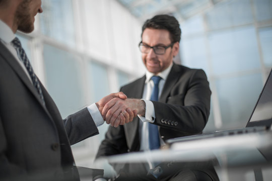 business people shaking hands over a Desk