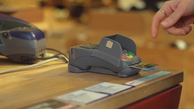 Person uses card reader in store, close up