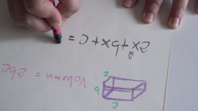 Students doing homework in math and drawing formulas to solve equations on paper in the classroom. Studying learning in school
