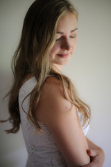 Lifestyle: Woman with Long Hair in a White Eyelet Dress in a Studio Setting with Natural Light