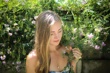 Lifestyle: Beautiful Caucasian woman Outside in Nature with Green Foliage in Spring or Summer. Shallow Depth of Field.