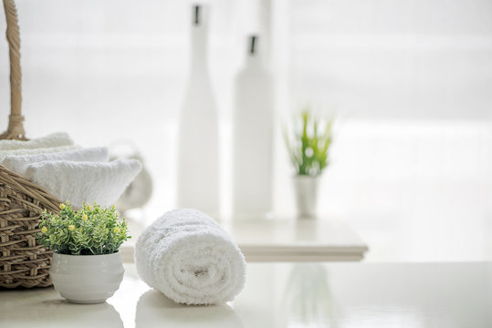 White towels on white table with copy space on blurred bathroom background.