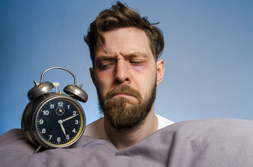 Closeup, man looking angry at the alarm clock 