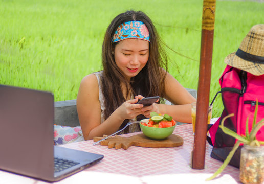 happy and pretty digital nomad Asian Chinese girl taking picture of fruit salad with mobile phone for sharing on internet social media healthy nutrition