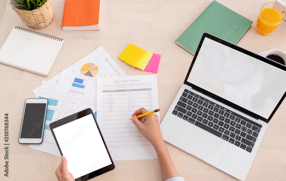Poster top view woman use tablet and writing on paper sheet with laptop working online on table at home.mock up template device screen.Digital lifestyle concept.clipping path screen.