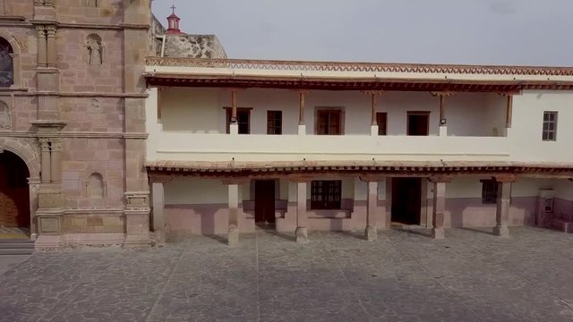 Vista lateral de la Parroquia de Aculco con el padre entrando por una puerta