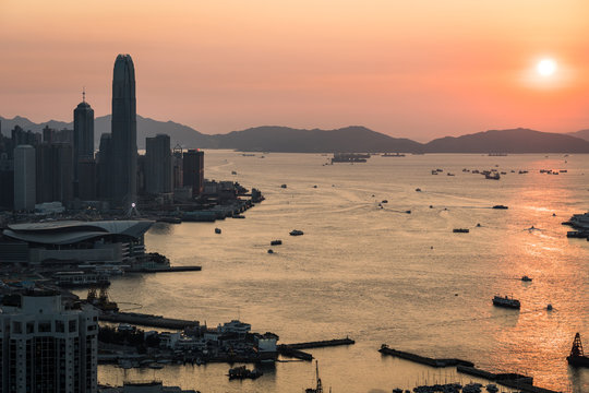 Stunning view of the sunset above the Victoria harbor in Hong Kong with the skyscraper of Hong Kong island in the left in China