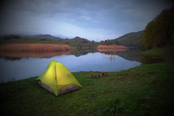 Obraz premium Illuminated Tent By Lake In Overcast Evening, Sicily