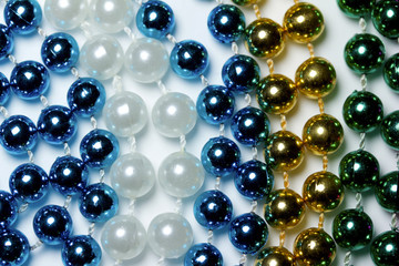 Macro view of bright colorful Mardi Gras beads with bokeh arranged in random fashion