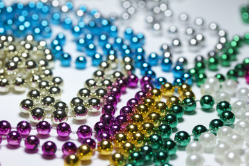 Macro view of bright colorful Mardi Gras beads with bokeh arranged in random fashion